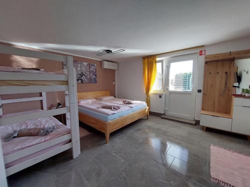 a bedroom with two bunk beds and a window at Apartma Žirovnik in Cerklje na Gorenjskem