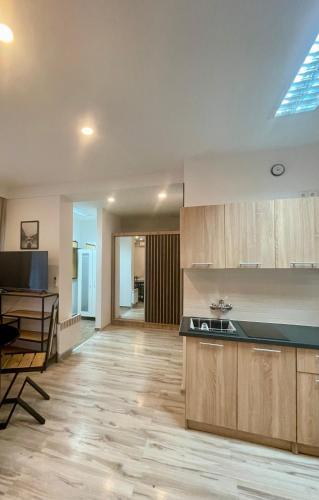 a kitchen with wooden cabinets and a black counter top at Via Słubice in Słubice
