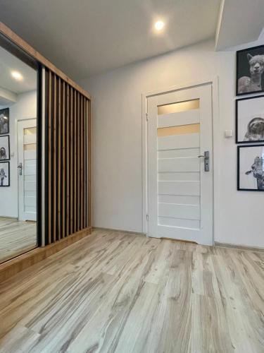an empty room with a door and a wooden floor at Via Słubice in Słubice