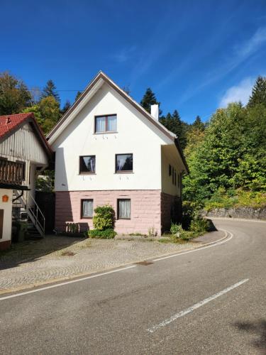 una casa blanca y roja al lado de una carretera en Ferienhaus Auszeit en Seebach