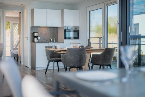 een keuken en eetkamer met een tafel en stoelen bij Schwimmende Ferienhäuser auf dem See - Spreewald in Vetschau