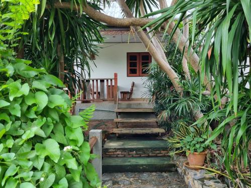 a stairway leading to a house in a garden at Sawasdee Sichang Resort in Ban Tha Thewawong