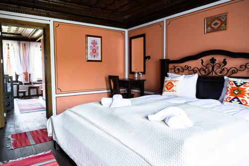 a bedroom with a large bed with white sheets at Къща ЕТНО in Koprivshtitsa