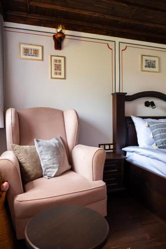 a living room with a chair and a bed at Къща ЕТНО in Koprivshtitsa