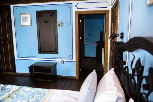 a bedroom with blue walls and a bed and a door at Къща ЕТНО in Koprivshtitsa