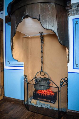 a fireplace in a blue room with a stove at Къща ЕТНО in Koprivshtitsa