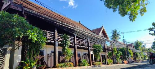 a building withtropical plants on the side of a street at Ancient Luangprabang Hotel in Luang Prabang