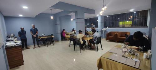 um grupo de pessoas sentadas em mesas em um restaurante em Hotel Bulande Comforts-1 Bedroom Flat em Bangalore