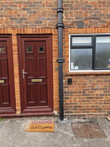 a brick building with two doors and a sign on the ground at Millmead Apartment in central Guildford with parking in Guildford