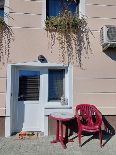 a red table and a red chair next to a door at Apartma Žirovnik in Cerklje na Gorenjskem