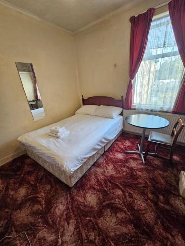 ein Schlafzimmer mit einem Bett und einem Tisch darin in der Unterkunft The 23 in London