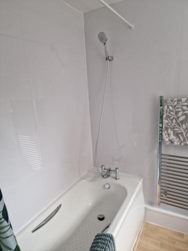 a white bath tub in a bathroom with a shower at Millmead Apartment in central Guildford with parking in Guildford