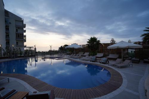 a large swimming pool with lounge chairs and umbrellas at Heaven Prestige Hotel in Jounieh