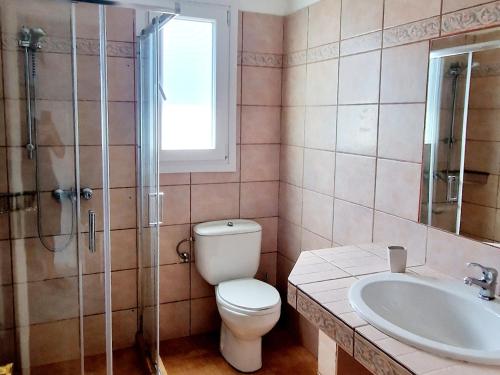 a bathroom with a toilet and a sink and a shower at Panorama Apartments Fiscardo in Fiskardho