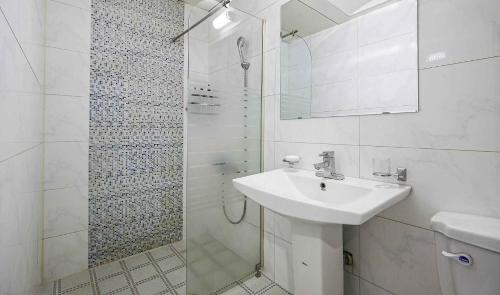 a white bathroom with a sink and a shower at Motel Lamant in Bucheon