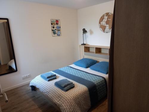 um quarto com uma cama com almofadas azuis em Aux Portes de Brest em Le Relecq-Kerhuon