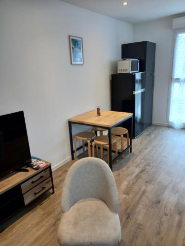 un salon avec une table et une chaise dans l'établissement Aux Portes de Brest, à Le Relecq-Kerhuon