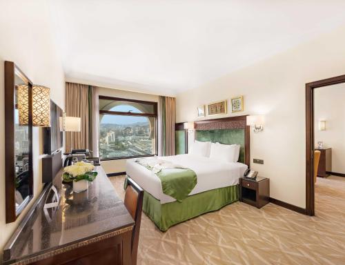 a hotel room with a bed and a large window at Anjum Makkah Hotel in Makkah