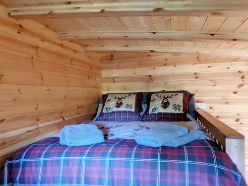 - un lit dans une cabane en rondins avec 2 oreillers dans l'établissement Chalets du golfe de st Tropez l olivier, à La Garde-Freinet