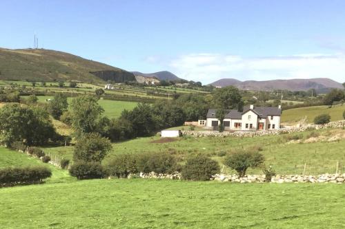 a house in the middle of a green field at Mourne Views 2 Bed Apartment in Kilkeel