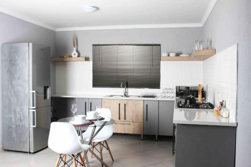 a kitchen with a refrigerator and a table and chairs at Tranquility at Homely Escape in Phalaborwa