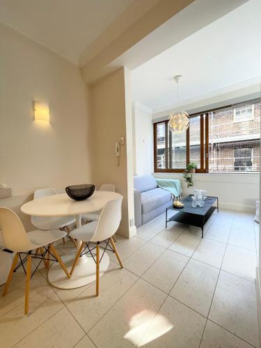 a living room with a table and chairs and a couch at Stylish apartment in the heart of Potts Point in Sydney
