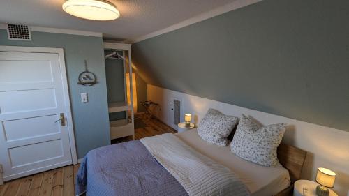1 dormitorio con cama y puerta blanca en Ferienhaus Hygge en Flensburg