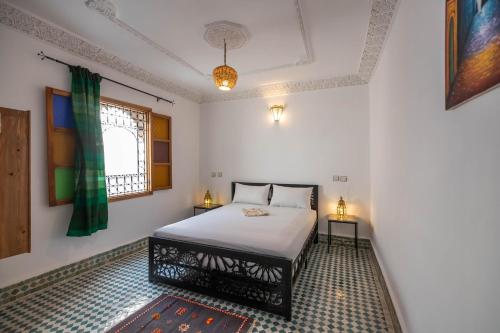 1 dormitorio con cama y ventana en Riad Tafoukt Fes, en Fez