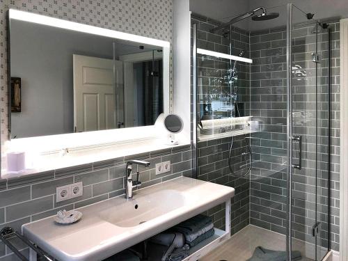 uma casa de banho com um lavatório, um espelho e um chuveiro em Villa Svanen am Meer em Timmendorfer Strand