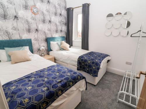 a bedroom with two beds and a window at Through the Looking Glass in Ripon