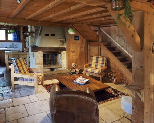 a living room with a fireplace and a table and chairs at Le Doubs Chalet - Chalet Garnache - Labellisé "Pêche" in Oye-et-Pallet