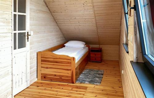 een klein bed in een houten kamer met een raam bij Gorgeous Home In Jaromierz With Sauna in Czarne Górne