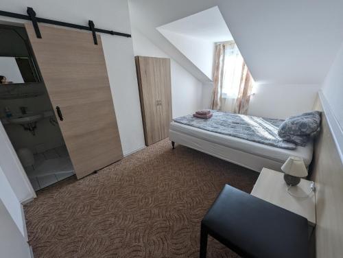 a small bedroom with a bed and a bathroom at Hotel Gästehaus Altena in Altena