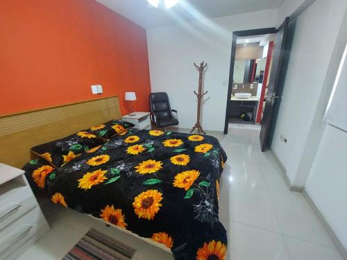 a bedroom with a bed with a black blanket with sunflowers at Mendoza in Mendoza