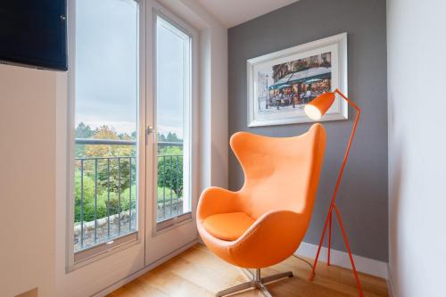 an orange chair in a room with a window at Parkview, St Andrews in St. Andrews
