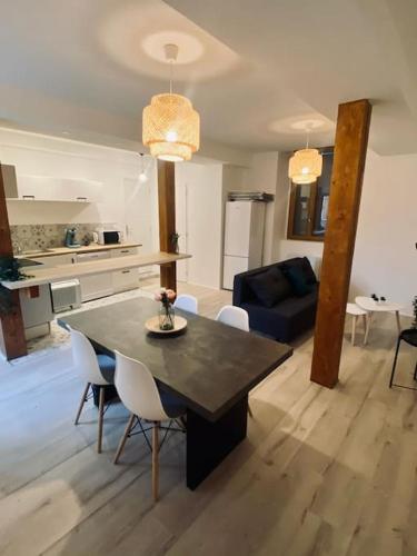 uma cozinha e sala de estar com mesa e cadeiras em Bel appart proche centre ville, thermes, casino em Bagnères-de-Bigorre