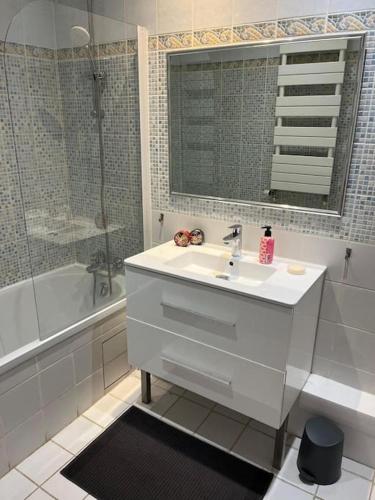 une salle de bain blanche avec un lavabo et une douche dans l'établissement Loft duplex d'exception de 120m2 Paul Bert, à Paris