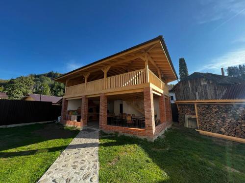 a large house with a deck and a building at Casa Bujor de Munte Dragoslavele in Dragoslavele