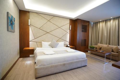 a bedroom with a large white bed and a couch at Heaven Prestige Hotel in Jounieh