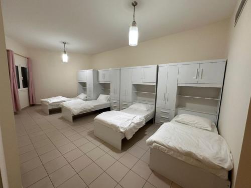 a room with three beds in it with lights w obiekcie Ruby Star Hostel Dubai for Female -4 R-1 w Dubaju