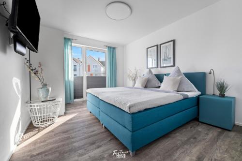 Schlafzimmer mit einem blauen Bett und einem TV in der Unterkunft Lieblingsort in Olpenitz