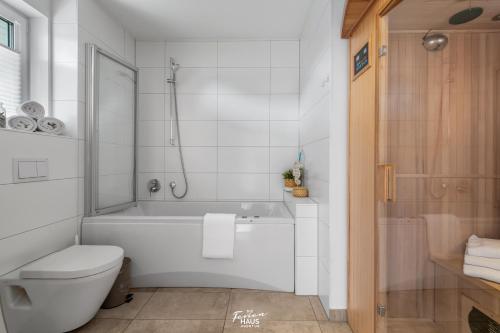 ein weißes Bad mit einer Badewanne und einem WC in der Unterkunft Lieblingsort in Olpenitz