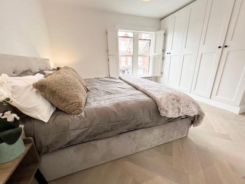 a bedroom with a bed and a window at Luxury Architect Designed Town House Near Beach in Littlehampton