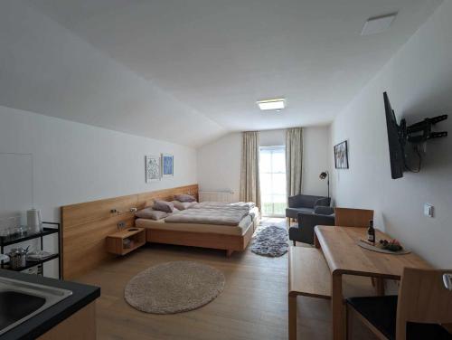 a bedroom with a bed and a kitchen with a sink at Pension Kricklsäge in Philippsreut