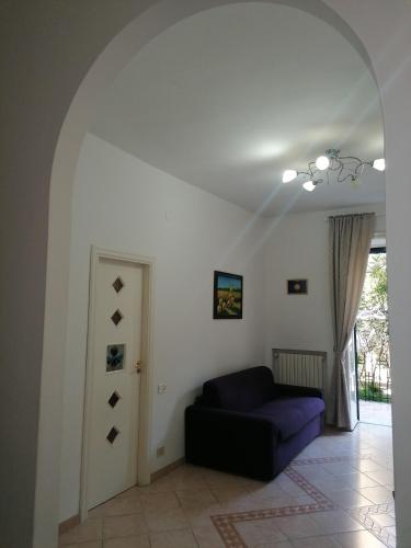 カーヴァ・デ・ティッレーニにあるCasa Annaの紫色のソファとドア付きのリビングルーム