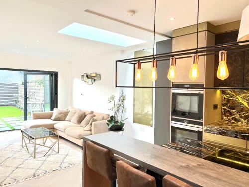 eine Küche und ein Wohnzimmer mit einem Sofa und einem Tisch in der Unterkunft Luxury Architect Designed Town House Near Beach in Littlehampton