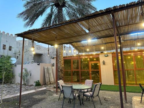 a patio with a table and chairs under a pergola at AL- aqyr Rest Garden أستراحة حارة العقر in Nizwa