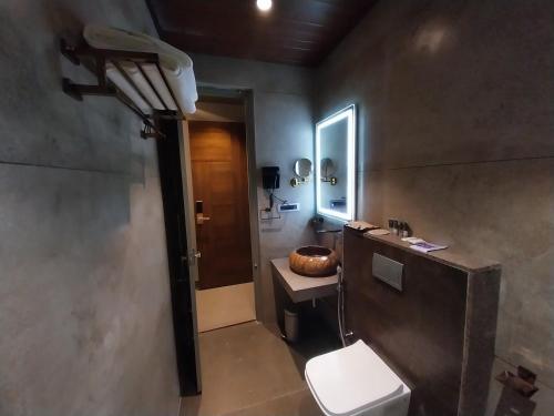 a bathroom with a toilet and a sink and a mirror at SScoconest Luxury Service Apartments in Chikmagalūr