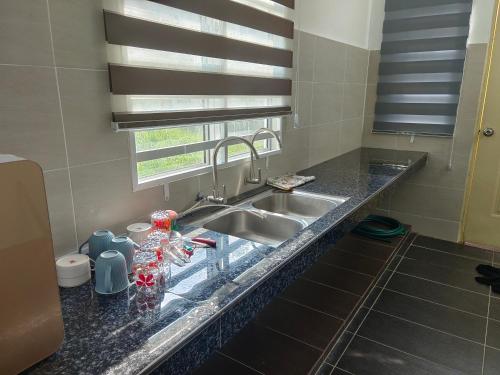 a kitchen counter with a sink and a window at HOMESTAY MYROKMA in Kampong Belukar
