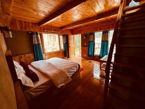 um quarto com uma cama numa casa de madeira em ThePahadians Food & Stay em Jibhi
